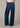 Person wearing blue jeans on a plain background