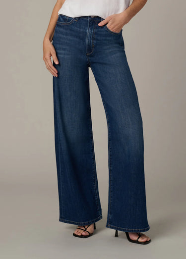 Person wearing blue wide-leg jeans on a neutral background