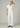 Woman wearing a white outfit against a plain background