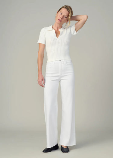 Woman wearing a white outfit against a plain background