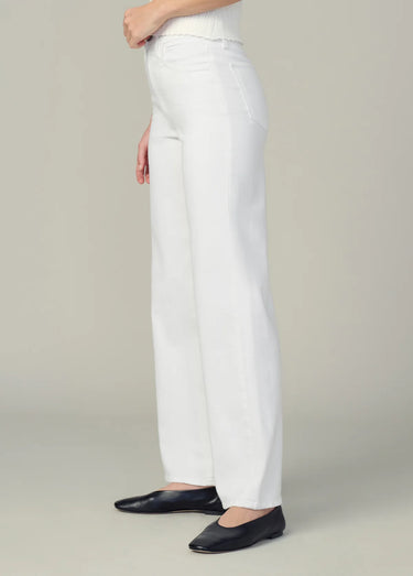 White pants worn by a person on a plain background