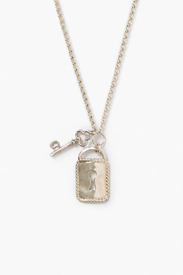 A close-up of a sterling silver necklace with a rectangular lock pendant featuring a keyhole and an ornate key charm, against a bright white background.