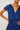 Woman wearing a blue floral dress against a white background