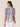 Woman wearing a colorful patterned blouse against a beige background