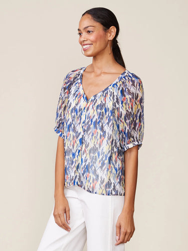 Woman wearing a colorful blouse with a plain background