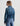 Person wearing a blue denim jacket and jeans on a white background