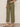 Person wearing olive green pants with a plain background