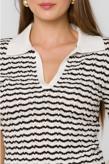 Close-up of a person wearing a black and white striped shirt with a collar.