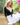 Woman in a black cardigan and white dress standing outdoors with greenery and flowers in the background