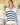 Woman wearing a white and navy striped sweater holding a glass of orange juice.