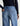 Person wearing blue jeans with a plain background