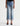 A model is shown from the waist down wearing a pair of light-wash blue cropped jeans with rolled cuffs, paired with black pointed-toe heels against a plain white studio background.