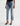 Light blue jeans with rolled-up cuffs worn by a person on a white background