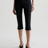 Person wearing black capri pants on a white background