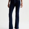 Person wearing dark blue jeans on a white background