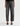 A woman  wearing  dimensional ashy black wash jeans, with contrasting paneled detailing and a black top with black heels on a white background.