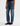 A woman wearing high rise barrel jeans in medium wash with a short sleeve maroon tee and black loafers on a white background.