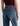 A woman facing backwards wearing high rise barrel jeans in medium wash with a short sleeve maroon tee and black loafers on a white background.