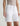 Person wearing white denim shorts on a plain background