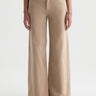 A woman wearing wide leg tan corduroy pants with a relaxed silhouette on a white background
