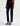 A woman facing sideways wearing low rise straight dark blue jeans and black heels on a white background.