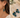 Teardrop-shaped blue-green gemstone drop earrings with gold wire-wrapped caps and gold fishhook wires, shown worn on a model's ear and displayed on a stone surface.