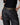 Person wearing black cargo pants with a belt on a gray background