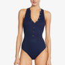 Woman wearing a navy blue swimsuit with buttons on a white background