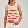 Woman wearing a sleeveless striped top and white shorts on a plain background