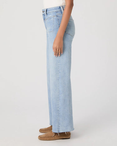 High rise vintage inspired light blue jeans worn by a person on a white background