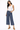 A woman wearing a white thank and dark cropped denim jeans