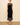 A woman wearing a midi dress with high lace neckline, a velvet body and a lace trim n a neutral background