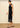 A woman wearing a midi dress with high lace neckline, a velvet body and a lace trim n a neutral background