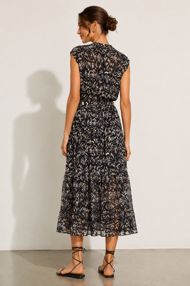 Woman wearing a black floral dress against a white background