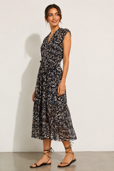 Woman wearing a black and white patterned dress against a plain background