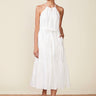 Woman wearing a white halter neck dress on a beige background