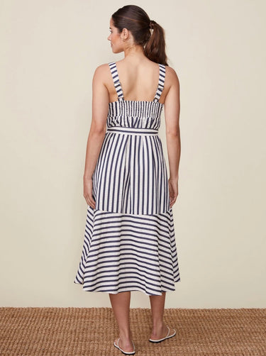 Woman wearing a black and white striped dress on a beige background