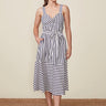 Woman wearing a black and white striped dress on a beige background