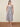 Woman wearing a black and white striped dress on a beige background