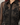 A close-up of a sheer black button-up shirt with intricate black beaded floral embroidery and sequined embellishments on the front.