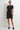 Woman wearing a black dress against a white background