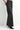 A model wearing black embellished wide leg jeans and black heeled boots on a white background.