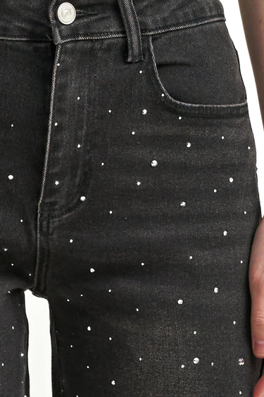A close up on embellished black jeans on a white background