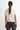 Person wearing a white sweater and black pants on a white background