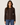 A woman modeling a dark brown ribbed knit cardigan sweater with a button-down front, paired with blue jeans, against a plain light beige background.