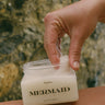 A woman using body scrub on the beach