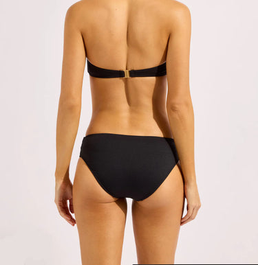 A black bikini bottom on a model on a neutral background