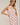Woman wearing a strapless pink and white striped dress against a plain background