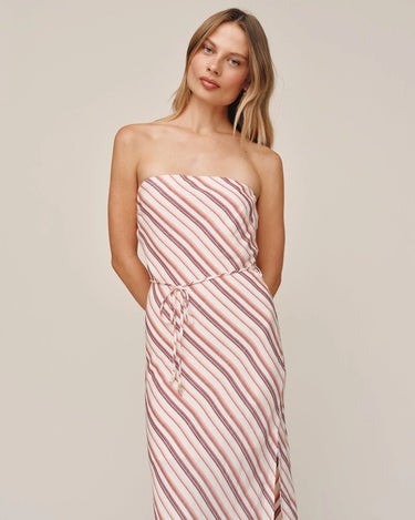 Woman wearing a strapless pink and white striped dress against a plain background