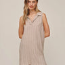 Woman wearing a striped sleeveless dress on a plain background